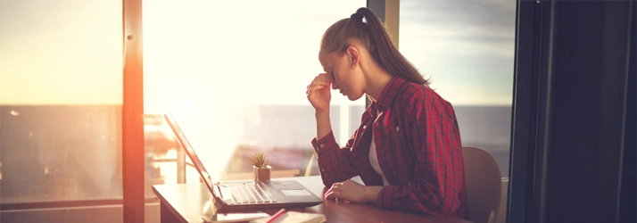 Eye Doctor Brainerd Rd Chattanooga TN Prevent Eye Fatigue A woman holding her forehead in front of a laptop.