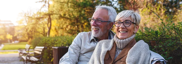 Eye Doctor Cleveland TN Happy Couple 1 An older happy couple sitting on a park bench in fall.