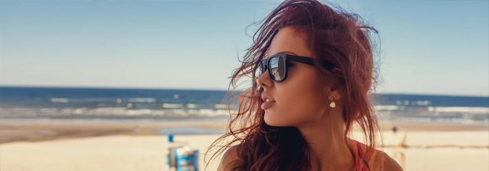 Eye Doctor Shallowford Rd Chattanooga TN Sunglasses A woman sitting at the beach in sunglasses.