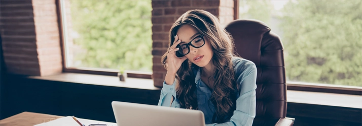 Eye Doctor Shallowford Rd Chattanooga TN Woman In Glasses A stressed woman sitting at a desk while wearing glasses.