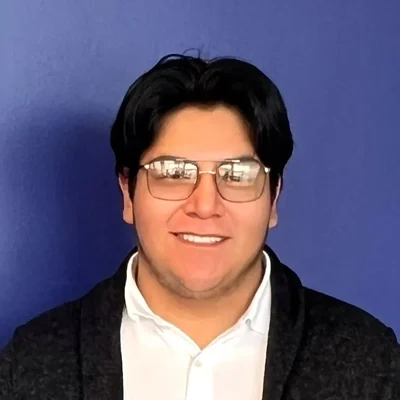 Eye Doctor Brainerd Rd Chattanooga TN Cristian Meet The Team Cristian smiling in front of a purple wall.