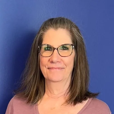 Eye Doctor Brainerd Rd Chattanooga TN Kristi Meet The Team Kristi smiling in front of a purple wall.