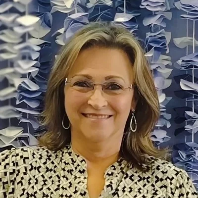Wanda smiling while wearing glasses.