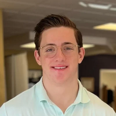Dash smiling, he is wearing glasses.