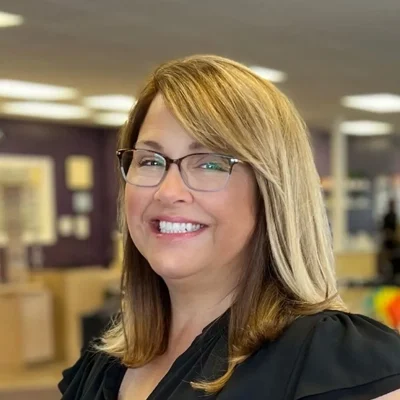 Genia smiling while wearing glasses.