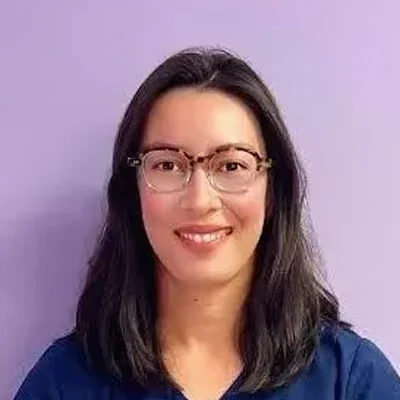Greyssy smiling in front of a purple wall.